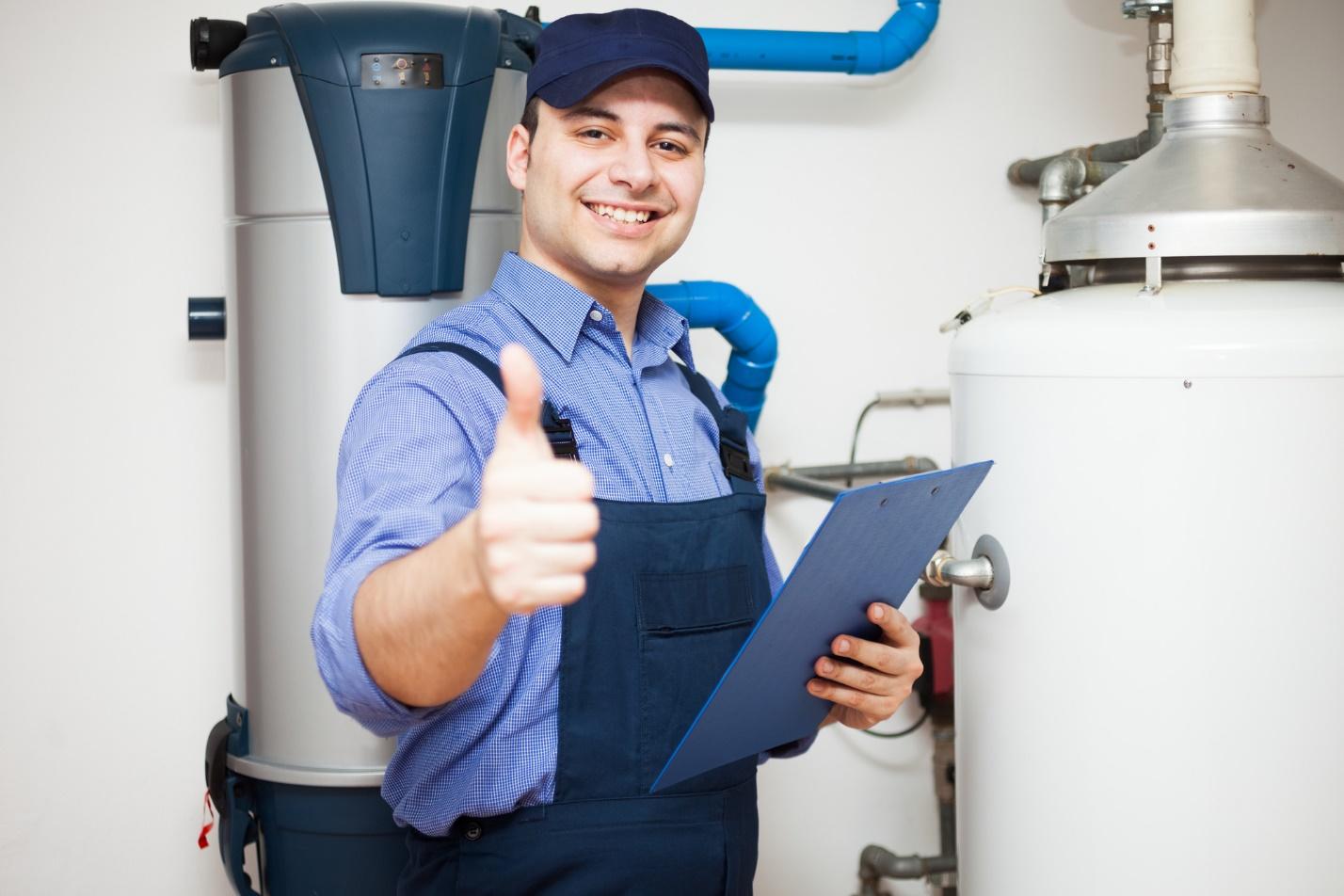 A person in overalls holding a clipboard and giving a thumbs upDescription automatically generated