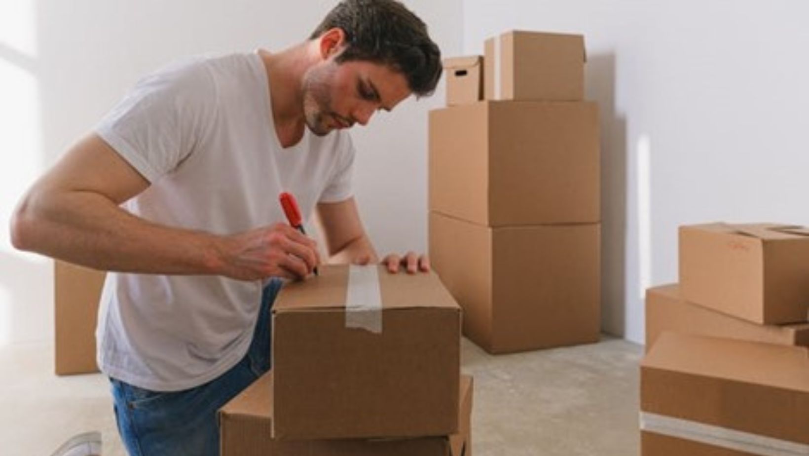 A man labeling a box for moving