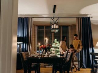 Family enjoying a cozy dining space that demonstrates creating visual balance when old furniture meets a new interior with classic wood pieces and modern décor.